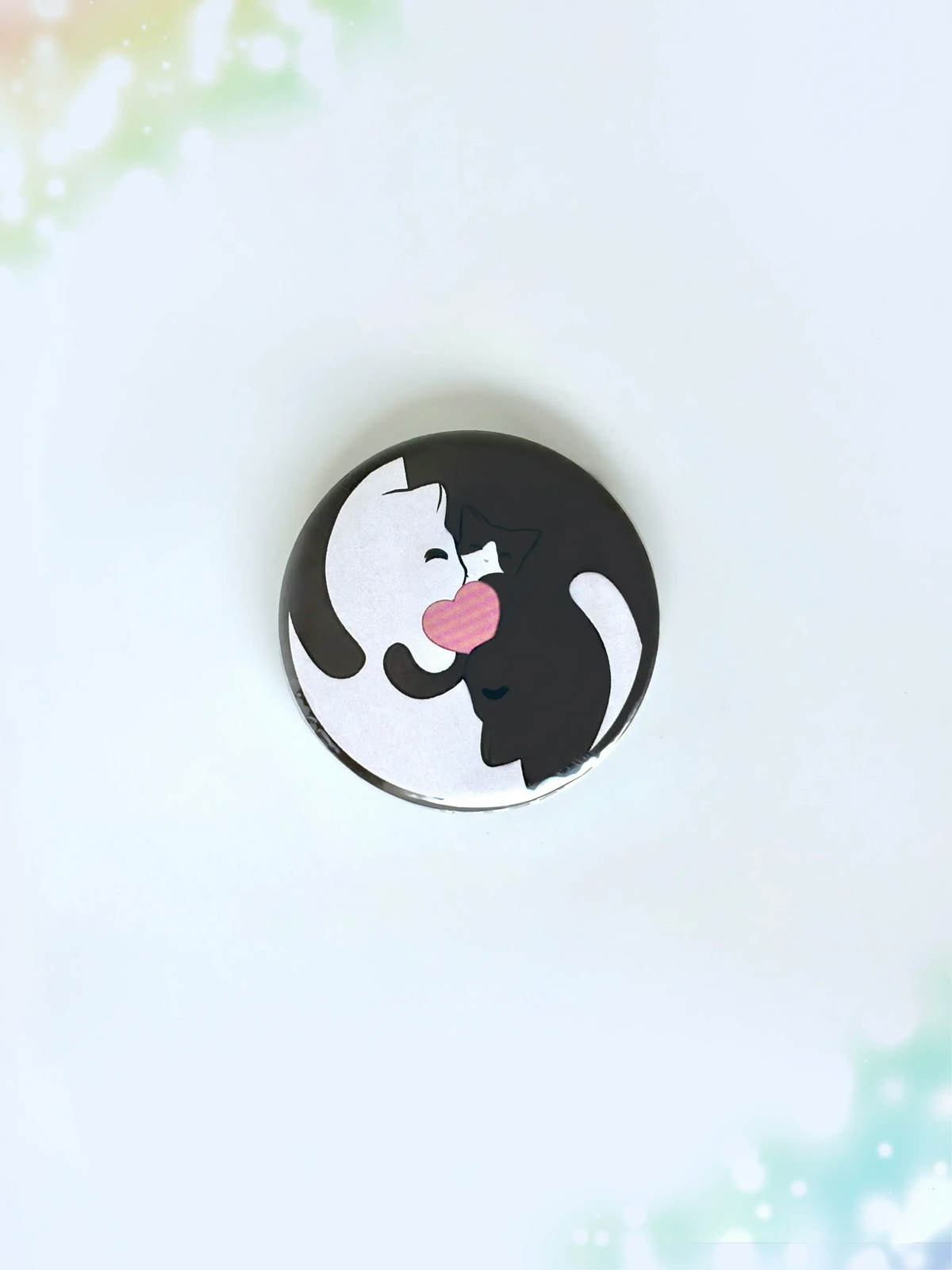 Cute anime style black and white cats cuddling together with a pink heart center button badge.